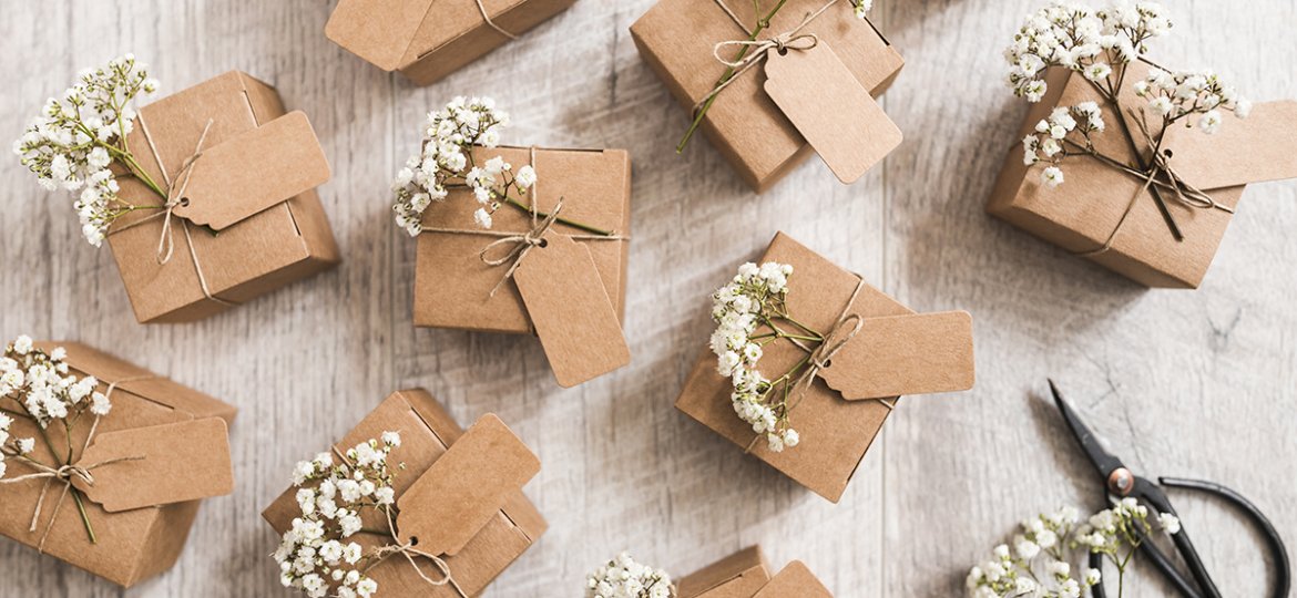 Square brown gifts with wedding flowers intwined