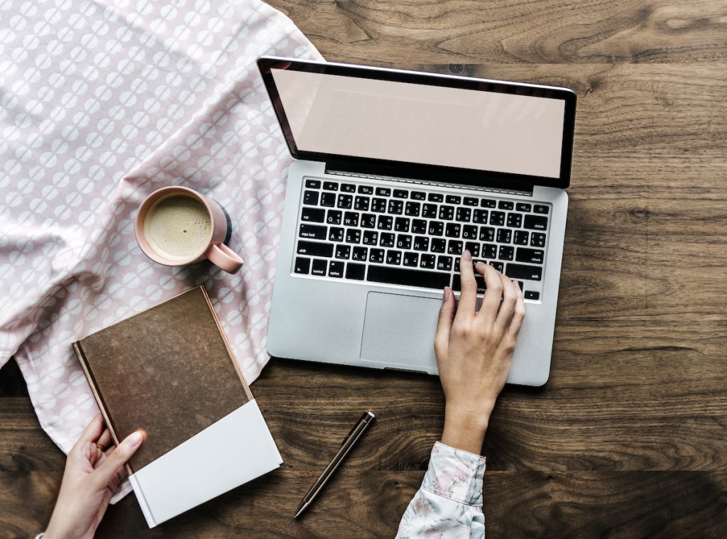 Laptop and notebook on wooden table